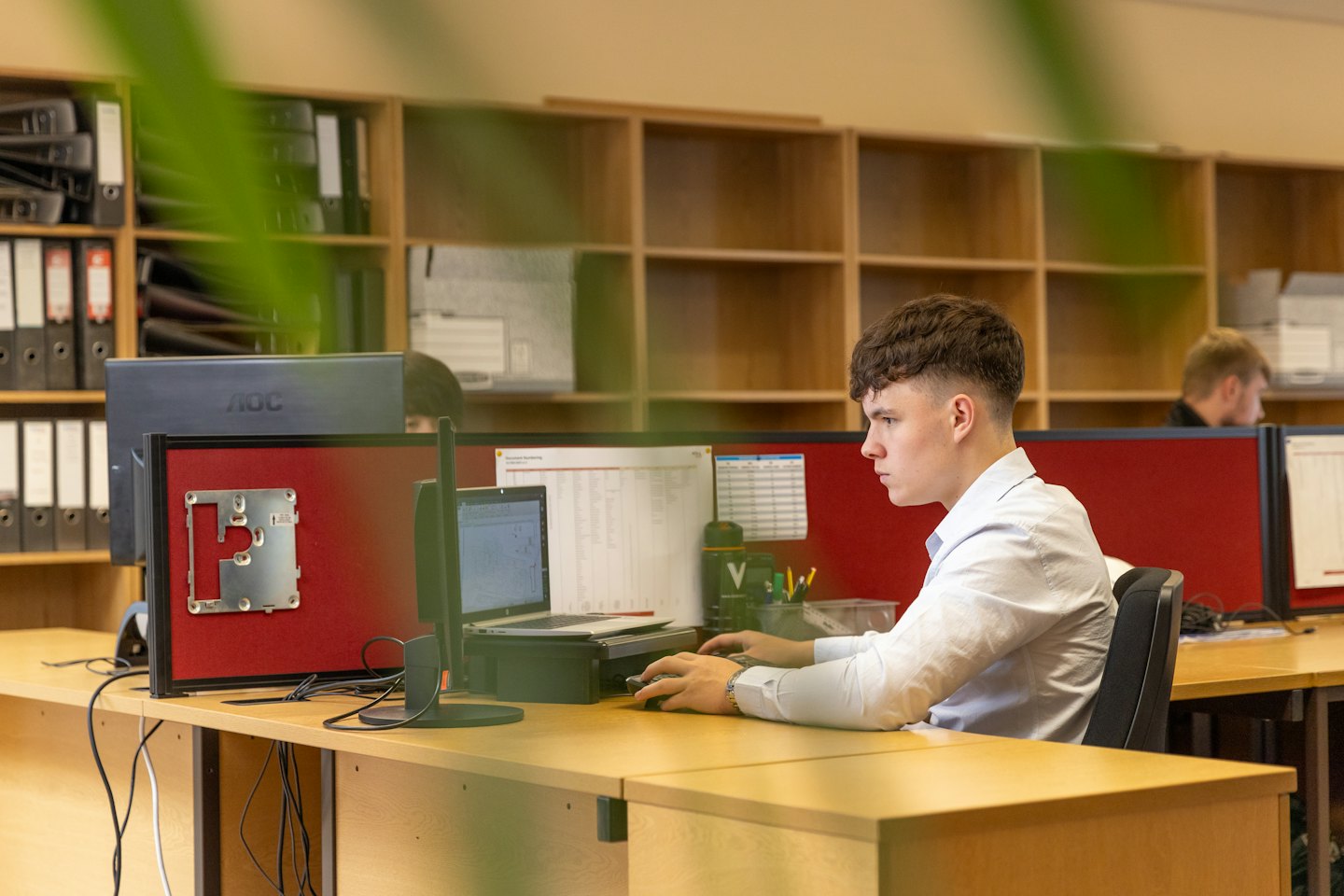 Man types on a computer at a modern office desk.